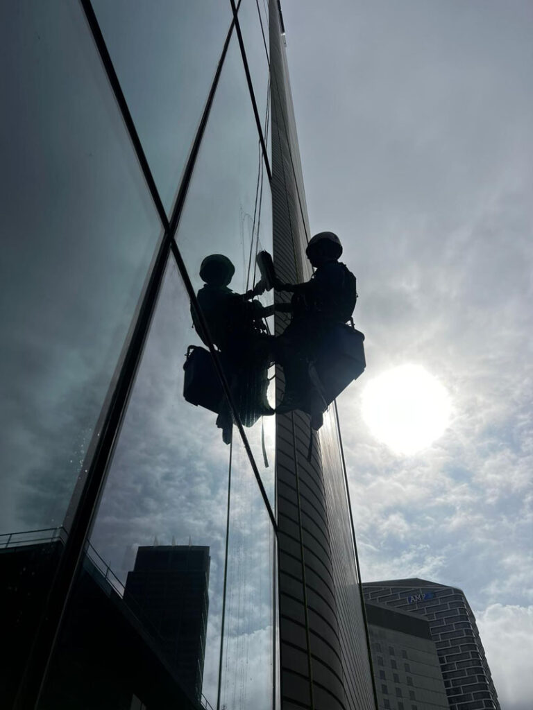 commercial high rise window cleaning with sun in the background