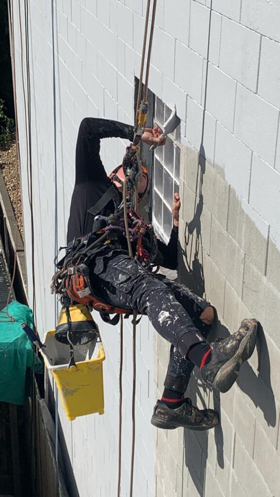 High rise painting technician, painting a building